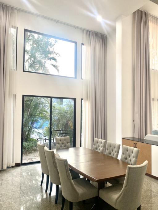 Bright dining area with large windows and a view of greenery