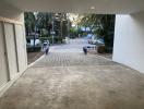 Spacious driveway leading to a residential building with greenery around