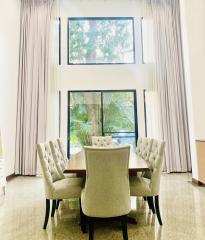 Elegant dining room with high ceiling and large window