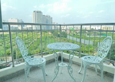 Spacious balcony with a view of the city skyline and outdoor seating