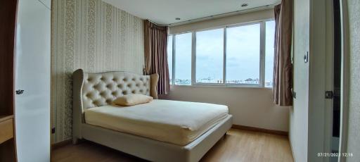 Bright and spacious bedroom with large window and comfortable bed