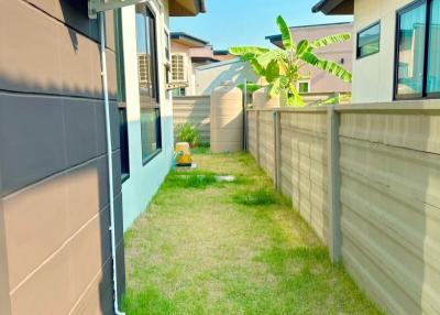 Side yard with grass and partial view of the house exterior
