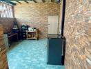 Compact kitchen area with stone wall design and blue floor tiles