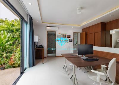 Modern home office with large desk, ergonomic chairs, and a view to the garden
