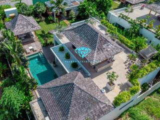 Aerial view of a luxurious property with a swimming pool and tropical landscaping
