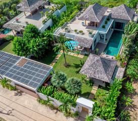 Aerial view of tropical villa with pool and lush garden