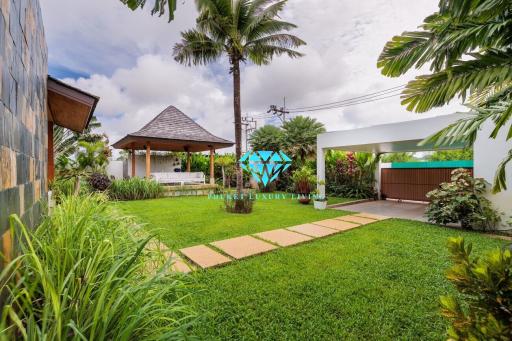 Spacious garden with a gazebo and tropical landscaping