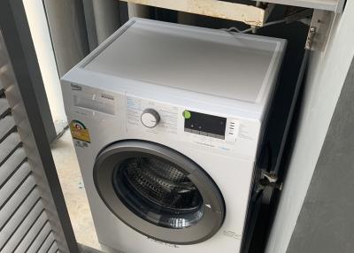 Compact laundry room with a modern washing machine