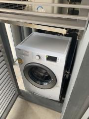 Compact laundry room with a modern washing machine