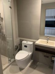 Modern bathroom interior with glass shower, toilet, and sink