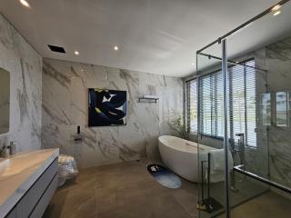 Spacious modern bathroom with marble tiles and freestanding tub