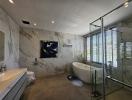 Spacious modern bathroom with marble tiles and freestanding tub