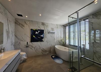 Spacious modern bathroom with marble tiles and freestanding tub
