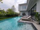 Modern house exterior with pool and lounging chairs
