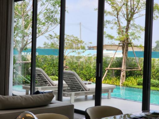 Luxurious living space with pool view through floor-to-ceiling windows