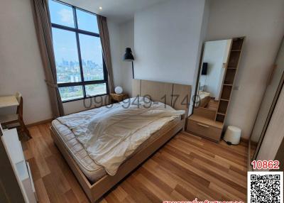 Bright bedroom with large window and city view