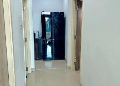 Bright hallway with tiled flooring leading to a glass door