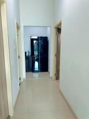 Bright hallway with tiled flooring leading to a glass door