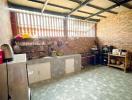 Spacious kitchen with tiled flooring and exposed brick wall