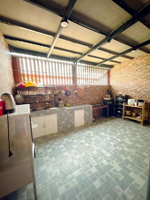 Spacious kitchen with tiled flooring and exposed brick wall