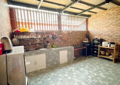 Spacious kitchen with tiled flooring and exposed brick wall