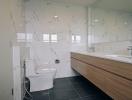 Modern bathroom with marble walls and dark tiled floor