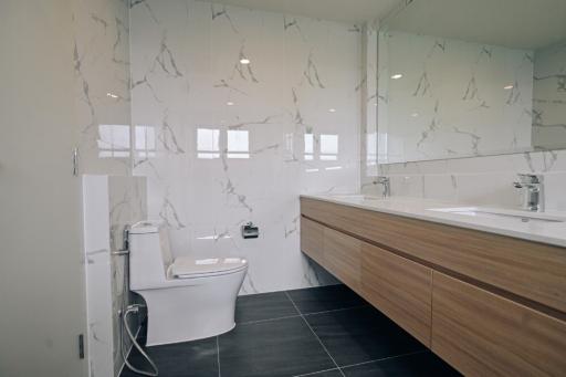 Modern bathroom with marble walls and dark tiled floor