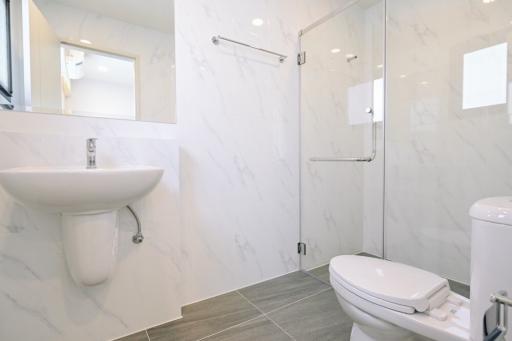 Modern bathroom with marble tiles and glass shower enclosure