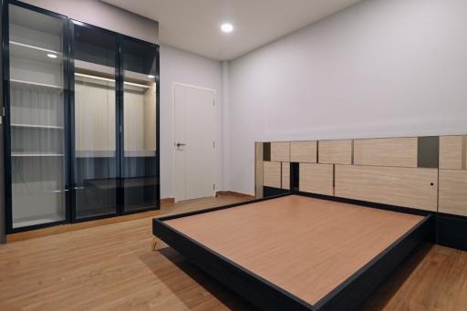 Modern bedroom with wooden flooring and large closet