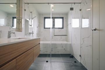 Modern bathroom with marble tiles and glass shower door