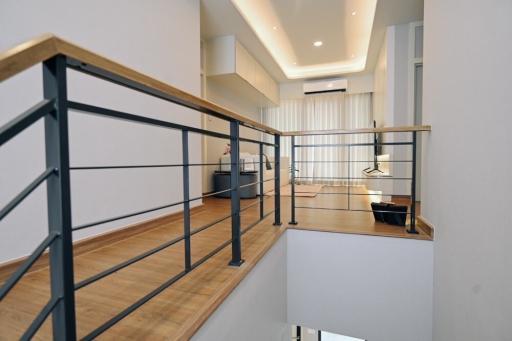 Elegant modern interior view from upper floor with wooden flooring and staircase