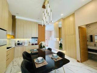 Modern kitchen with dining area, elegant lighting, and marble flooring