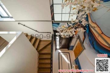 Modern staircase with artistic wall designs and high ceiling