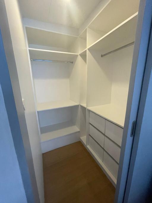 Spacious walk-in closet with built-in shelves and drawers