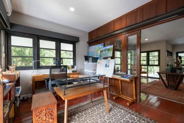 Spacious home office with large windows and wood paneling