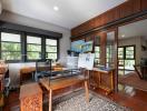 Spacious home office with large windows and wood paneling