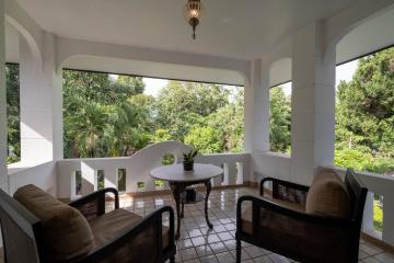 Spacious balcony with a serene view, comfortable seating and tiled flooring