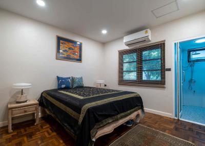 Cozy bedroom with queen size bed, air conditioning, and hardwood floors
