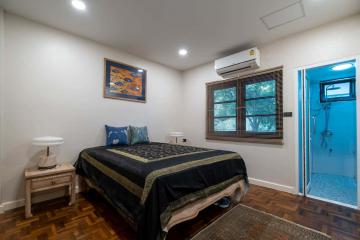 Cozy bedroom with queen size bed, air conditioning, and hardwood floors