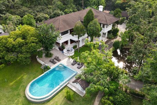 Aerial view of a luxury home with swimming pool and lush greenery