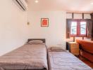 Cozy bedroom with twin beds, air conditioning and ample natural light