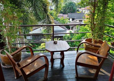 Cozy balcony with wooden furniture and lush greenery