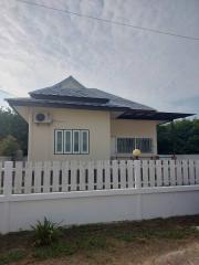 Single-story residential home with a white picket fence and an air conditioning unit