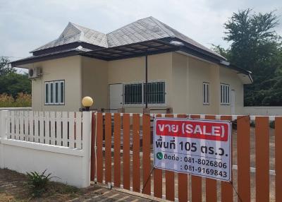 White single-story house with fence and for sale sign