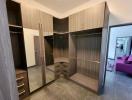 Spacious bedroom with large mirrored wardrobe and view into the living room