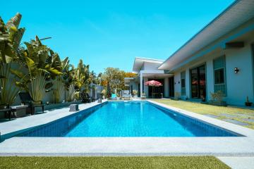 Elegant outdoor swimming pool with adjacent lounge area in a sunny backyard