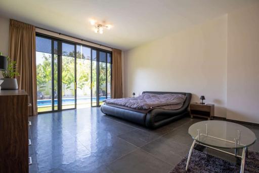 Spacious bedroom with direct access to pool view through sliding glass doors