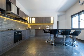 Modern kitchen with bar stools and integrated appliances