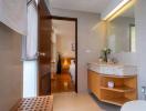 Modern bathroom with quality finishes leading to a warmly lit hallway