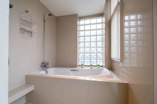 Spacious bathroom with glass block window and large bathtub